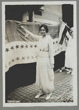 Suffragist Alice Paul dons a white dress and raises a glass shortly after the passage of the 19th Amendment in 1920. 