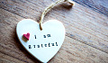 the words I am grateful, on a heart-shaped design