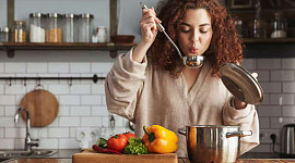 woman tasting food as it is cooking